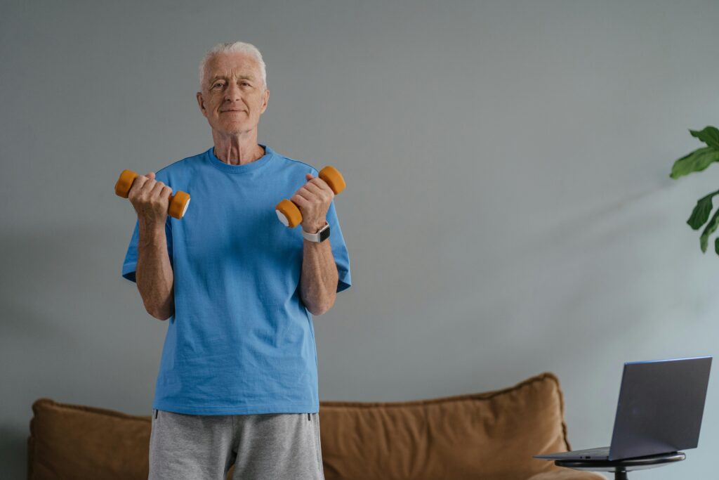 pexels-photo-8899526-8899526 Elderly man lifting dumbbells indoors, promoting a healthy lifestyle.